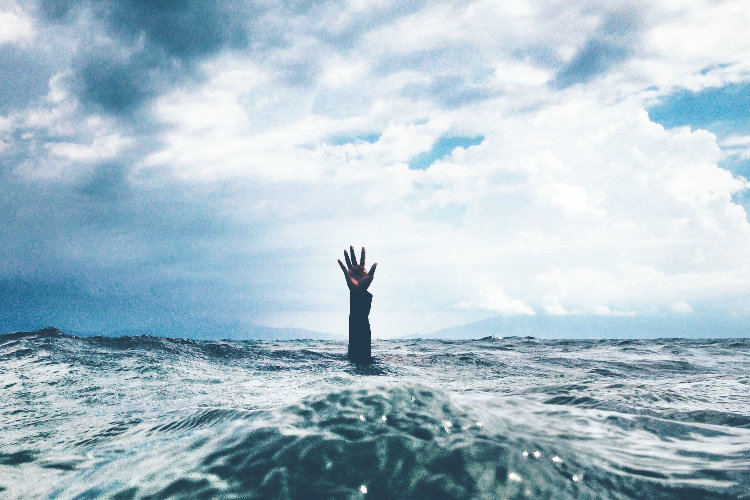 Drowning man with one arm sticking up out of water
